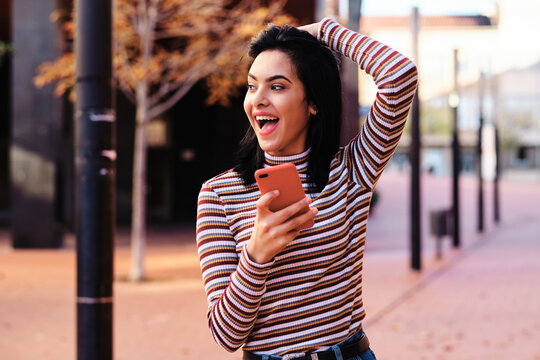 Young Middle East Girl Using A Red Smartphone Outdoors