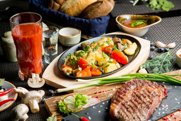 Tasty roast of vegetables and meat with tomato juice. Tomato juice in a glass.