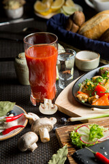 Tasty roast of vegetables and meat with tomato juice. Tomato juice in a glass.