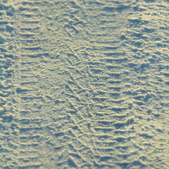 Tire tracks left in the snow on a bright sunny day