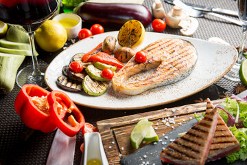 Grilled salmon steak. Fried vegetables: zucchini, tomato, eggplant, onion, pepper