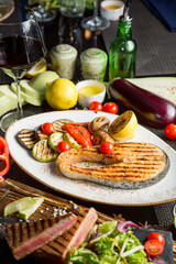 Grilled salmon steak. Fried vegetables: zucchini, tomato, eggplant, onion, pepper