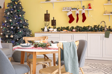 Beautiful table setting for Christmas dinner in kitchen