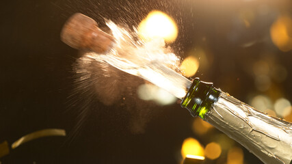 Champagne explosion with flying cork closure, opening champagne bottle closeup, celebration theme.