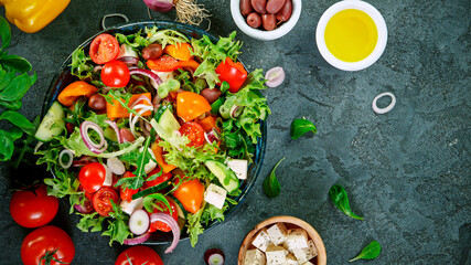 Fresh vegetable salad on black stone table, top shot. Healthy eating and lifestyle.