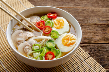 Japanese ramen soup egg, mushrooms and onion on wooden