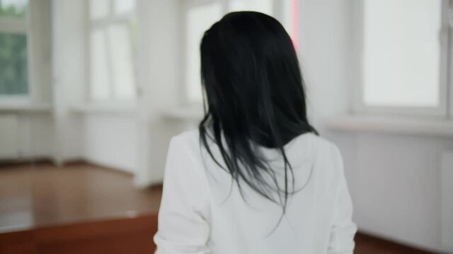 Sensualny taniec, czarnowłosej pięknej młodej tancerki w białym pomieszczeniu w zwolnionym tempie