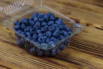 Fresh blueberry in plastic box on a wooden table