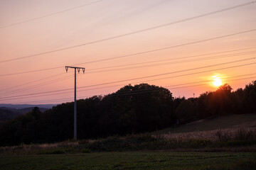 Coloful sunset behind a power line near Miesau, Germany on a summer night.