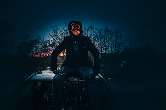 Purge mask, halloween with pumpkin. LED mask, creepy scary man. Corona, Funny, October, outside. Urban scene car