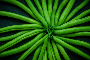 Green beans harvested in the middle on a black background