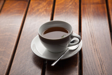 Cup of green tea on wooden table, evening relaxation