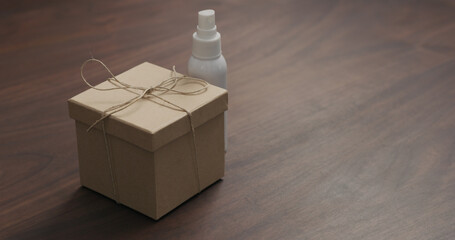 eco friendly paper gift box on walnut table with sanitizer spray