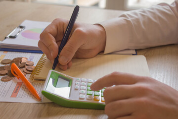person writing goals on a paper, writing business plan at workplace, man holding pens, papers, notes in documents, Saving money concept, graph, stacks of coins