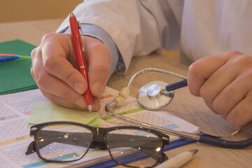 Doctor working at table in office. doctor concept in hospital. Hands of a doctor filling prescription, documents