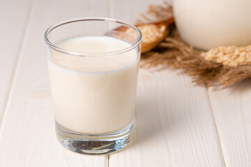 Glass cup of milk on white wooden table