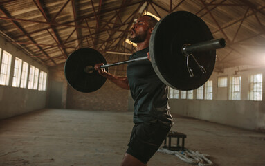 Fototapeta na wymiar Fit man lifting weights