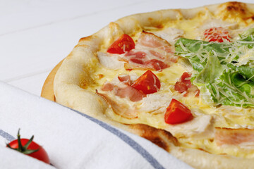 Caesar pizza on board on white wooden table