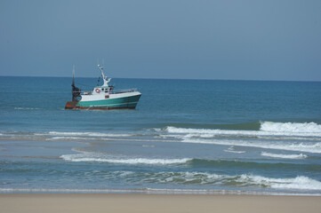 Naklejka premium Fisherman on his boat on the coast