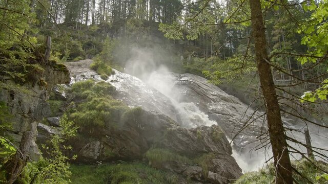 Waterfall in the mountains. Water flowing between rocks in the forest. Fast mountain river in rapid flow in nature. Power of water. River strong water rushes down. Simmental. Canton Bern. Switzerland.