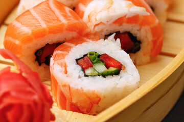 Sushi roll covered with salmon and prawn close up