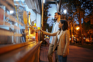 Love couple buying coffee in city amusement park