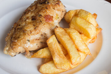 A plate of chicken food with vegetables and potatoes.