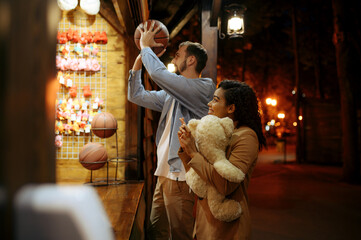 Couple play in shooting gallery, amusement park