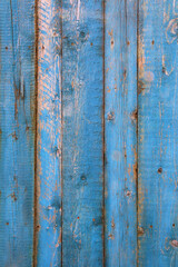 Shabby weathered wooden wall painted of bright blue paint