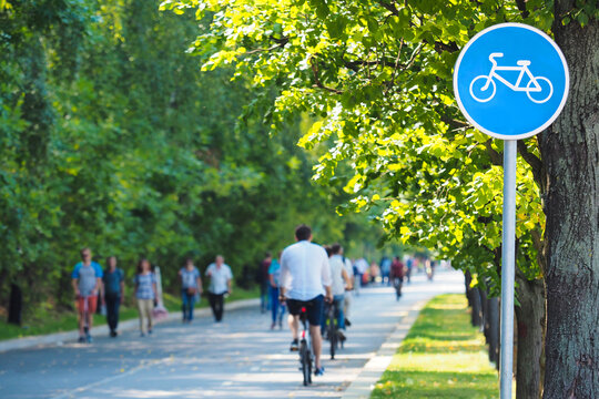 Bike Lane, Bike Path Sign In Summer Green Park. Cyclists On Bicycles And Pedestrians. Concept Of Rest And Relaxation, Exercise, Healthy Lifestyle