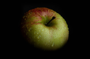 Wet apple on black background
