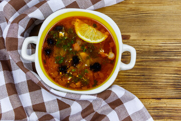 Traditional russian hodgepodge soup on a wooden table. Top view