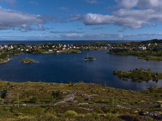 Beautiful panoramic view over Sørvågvatnet lake and fishing village Sørvågen located on coast of Norwegian Sea on Moskenesøy island, Lofoten, Norway on sunny day in late summer.