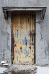 古いコンクリートの建物の赤錆びた鉄板の扉