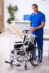 Young male doctor and skeleton in wheel-chair