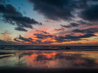 Fototapeta na wymiar Nubes en la puesta de sol anaranjada en la playa de Cádiz y Tarifa de Zahara de los atunes
