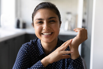 Headshot portrait of friendly mixed race woman remote employee looking at camera taking part in virtual event. Happy millennial female of indian ethnicity making videocall using home computer webcam