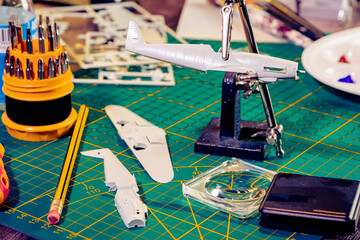 War plane toy model building or construction, handcraft on table with different materials.