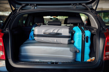 Suitcases in opened car trunk on parking, nobody