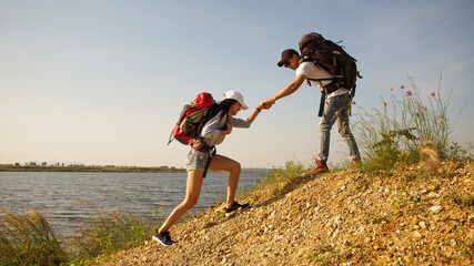 Couple backpacker helping each other during trekking on the way