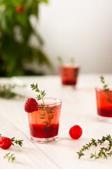 Raspberry alcoholic shots, shot glasses with colored liquor on a white background