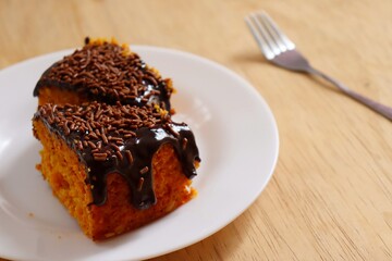 Carrot cake with chocolate on wooden background. Traditional Brazilian Carrot Cake.

