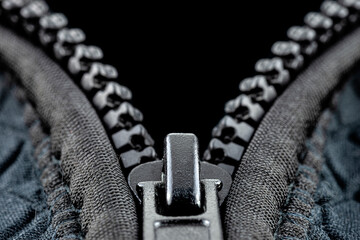 A macro shot of a open, plastic zipper in a modern blue garment.