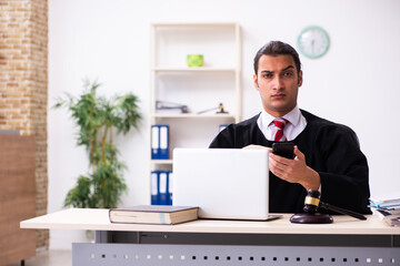 Naklejka premium Young male lawyer working in the courthouse