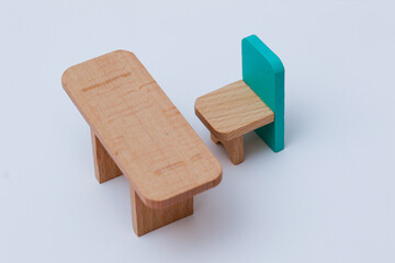One wooden toy chair with a blue back and a wooden table stand against a white background. Wooden Toys