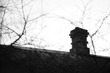 Old brick chimney on the rural roof, bw photo.