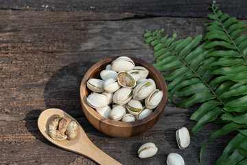 Pistachio nut in wooden bowl on rusty wood table background