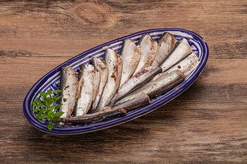 Anchovies in the bowl served basil leaves