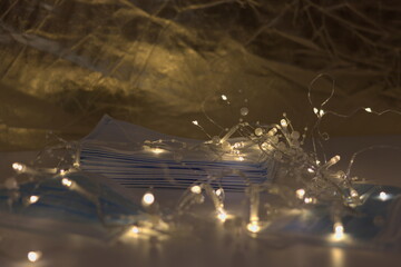 Background medical masks and wire mesh garlands on table - concept of attributes of Christmas and New Year 2021