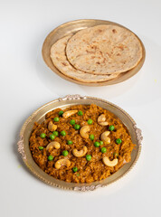 Rajasthani Famous Traditional Cuisine Haldi Sabji or Tukkar Served with Salad on White Background